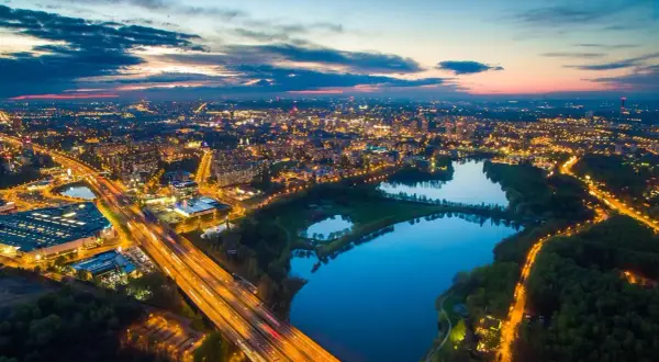 Nocny widok na miasto z lotu ptaka, oświetlona autostrada i trzy połączone jeziora tworzą malowniczą dolinę trzech stawów.
