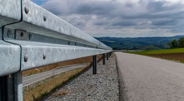Leitplanken schützen auf dieser kurvigen Landstraße. Sie sind aus Metall und sollen Fahrzeuge im Falle eines Aufpralls abfangen.