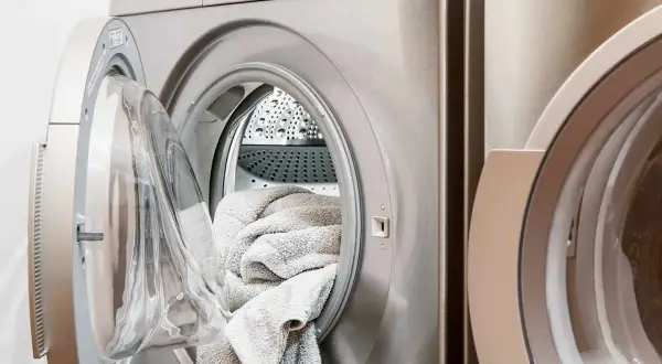 Pralka Beko z otwartymi drzwiczkami i włożonym ręcznikiem. Beko to znana marka sprzętu AGD.