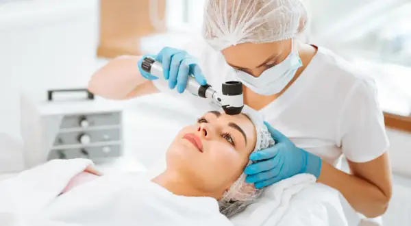 Dermatolog bada pieprzyk za pomocą dermatoskopu. Czy do dermatologs potrzebne jest skierowanie? Sprawdź!