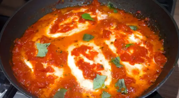 Una succulenta pizzaiola con mozzarella filante, cotta in padella con pomodoro e basilico fresco.