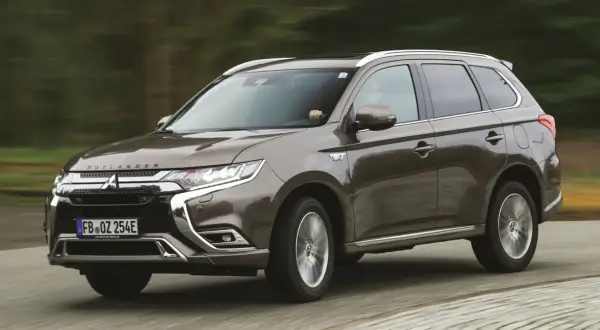 Brązowy Mitsubishi Outlander w ruchu. Wiele osób szuka mitsubishi outlander opinie, ten SUV jest świetnym wyborem.
