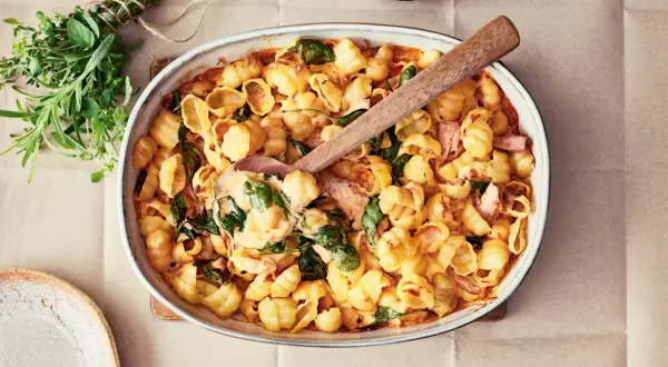Enkel lyxig middag: krämig pasta med spenat och skinka i ugnsform, redo att serveras.
