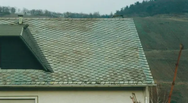 Dachziegel mit schuppenartiger Struktur, die auf Asbest hinweisen könnten. Vorsicht beim Umgang, um asbest dachziegel erkennen zu können.