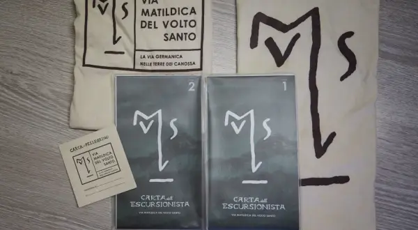 Kit per il pellegrino: sacca, credenziale e due carte dell'escursionista per la Via Matildica del Volto Santo.