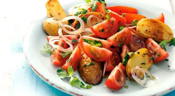 Tomaten-Kartoffel-Salat mit Zwiebeln und Kräutern, ein Beispiel für die vielseitige Majoran verwendung.