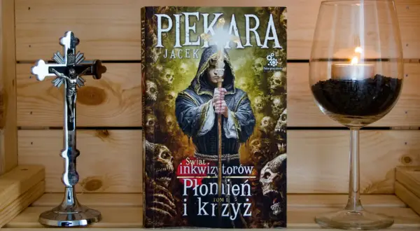 Książka "Świat inkwizytorów: Płonien i krzyż" obok krucyfiksu i świecy. Jacek Piekara opowiada o kolejności działań inkwizytora.