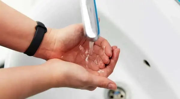 Dłonie pod bieżącą wodą z kranu. Zastanawiasz się, jak zmierzyć ciśnienie wody w kranie?