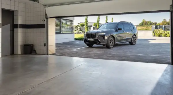 Nowoczesna posadzka w garażu, na której stoi luksusowy SUV.