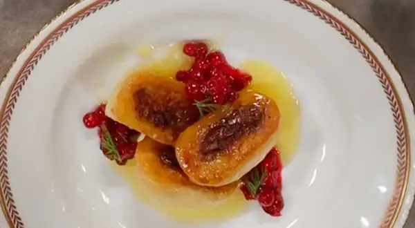 Tre gyllene kroppkakor serveras med lingon och en ljus sås. Ett vackert recept på kroppkakor!