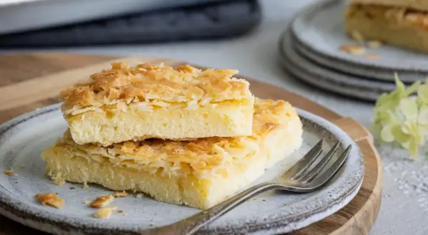Zwei Stücke saftiger Butterstreuselkuchen mit knuspriger Mandelkruste auf einem Teller. Ein köstliches Rezept für Butterstreuselkuchen.