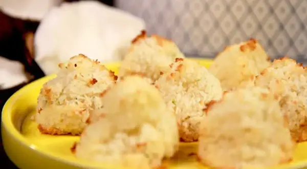 En gul tallrik med nybakade kokostoppar. Perfekt för dig som söker ett enkelt kokostoppar recept.