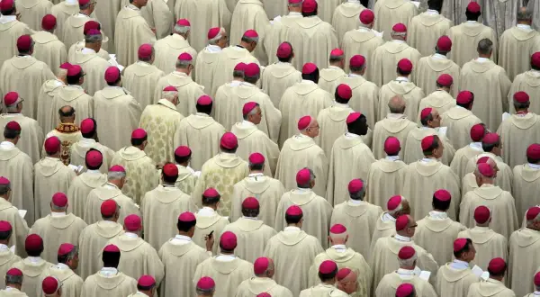 Tłum duchownych w białych szatach i różowych biretach, przypominający scenę z Soboru Watykańskiego II.