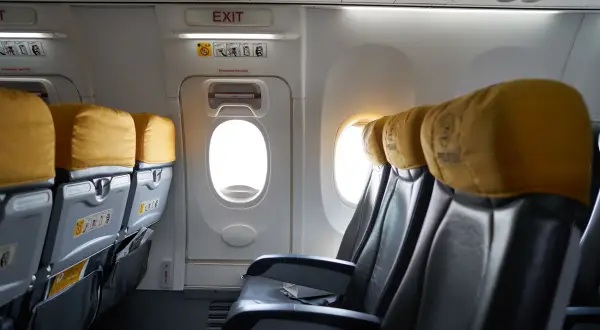Puste siedzenia w samolocie b737 z żółtymi zagłówkami i oknami.