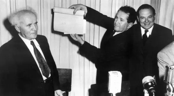 David Ben-Gurion hält ein Dokument hoch, das die Gründung Israels 1948 markiert.