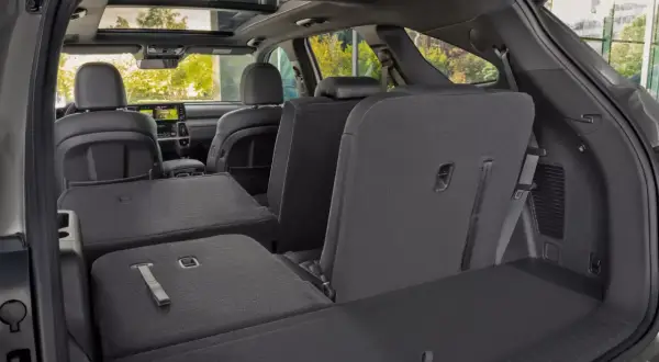Wnętrze Kia Sorento z rozłożonymi siedzeniami, ukazujące przestronność i możliwości aranżacji przestrzeni bagażowej. Idealne do transportu większych przedmiotów, co potwierdzają jego wymiary.