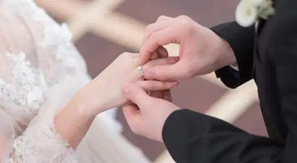 Ein Mann legt einer Frau einen Ring an den Finger. Die Frage, darf ein katholischer Pfarrer heiraten, bleibt hier offen.
