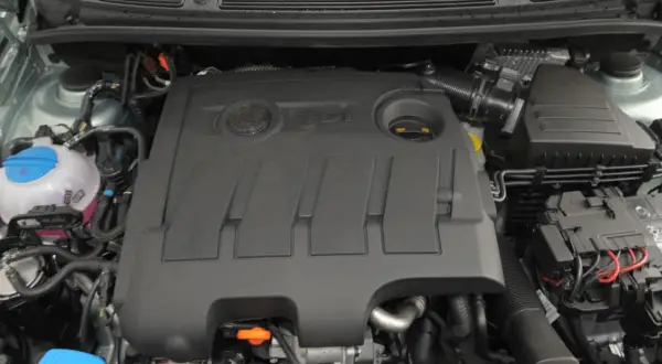 Silnik 1.6 TDI z widocznym logo TDI na pokrywie. Widać zbiornik płynu chłodniczego i elementy układu dolotowego.