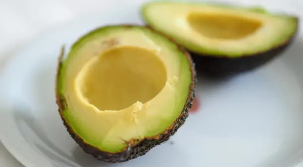 Dwa połówki awokado na talerzu, idealne do guacamole.