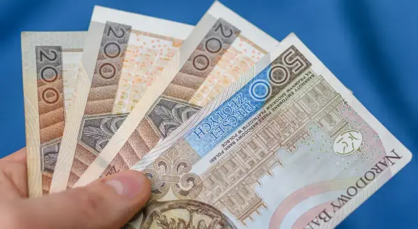 Dłoń trzyma polskie banknoty 200 zł i 500 zł. Chcesz wiedzieć, jak wypłacić pieniądze z funduszu inwestycyjnego Santander?