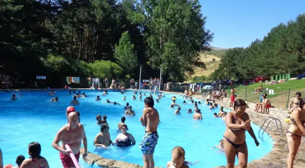Gente disfrutando de un día soleado en la piscina de la panera Segovia.