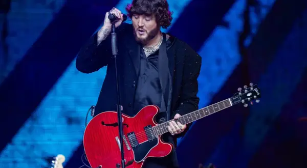 James Arthur śpiewa i gra na czerwonej gitarze na koncercie w Warszawie.
