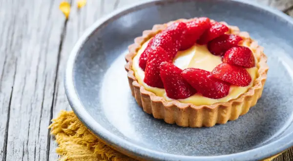 Tarte aux fraises sur pâte brisée, garnie d'une crème pâtissière onctueuse et de fraises fraîches. Un délice !
