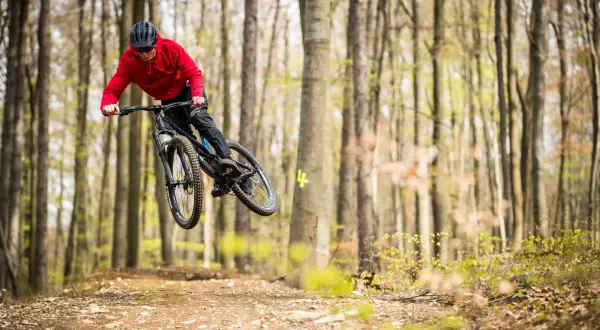 Mountainbiker springt in einem Bikepark in Tschechien über eine Schanze.