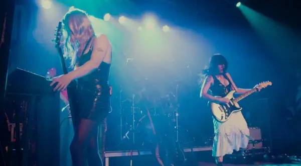 Mannequin Pussy rocks the stage, with one guitarist playing a keyboard and the other shredding a white electric guitar.