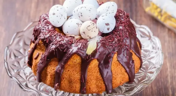 Babka gotowana przepis: puszysta babka z polewą czekoladową, posypką i ozdobiona wielkanocnymi jajeczkami.