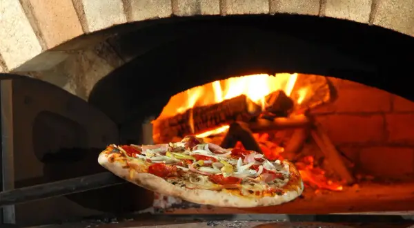 Piec opalany drewnem, a na łopacie gorąca pizza. Idealny kamień do pizzy to podstawa chrupiącego ciasta.