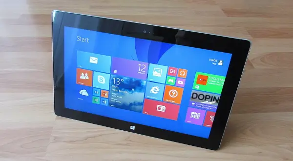 Tablet z interfejsem Windows 8, widok z góry, na drewnianym blacie.
