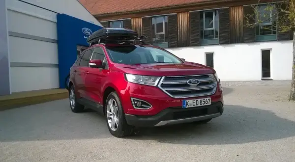 Czerwony Ford Edge z boxem dachowym, idealny na rodzinne wyjazdy. Sprawdź jego imponujące ford edge wymiary!