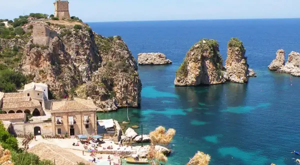 Scogliera con torre a Castellammare del Golfo, mare cristallino e faraglioni.