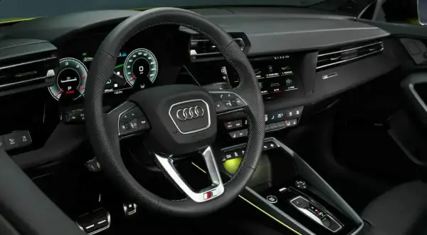 Wnętrze nowego Audi A3: cyfrowy kokpit, sportowa kierownica i nowoczesna konsola środkowa.