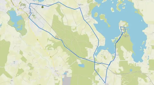 Mapa turystyczna z zaznaczoną trasą wokół miasta nad jeziorem Skiertąg. Widoczne jezioro, lasy i zabudowania.
