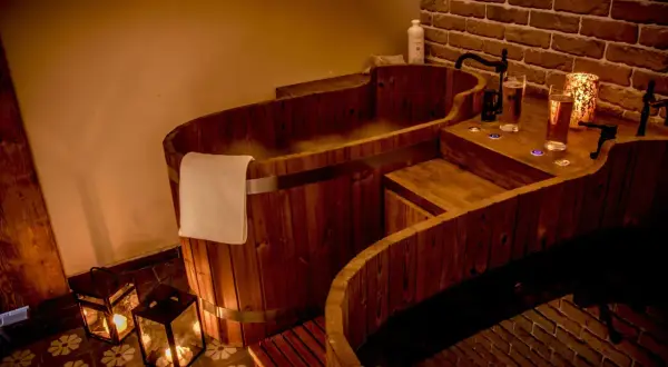 Drewniane wanny SPA z parą, świecami i napojami.