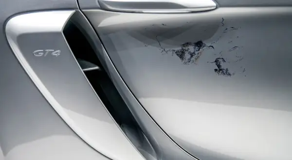 Na srebrnym lakierze Porsche GT4 schodzi lakier bezbarwny, tworząc nieestetyczne plamy. Jak naprawić ten problem?