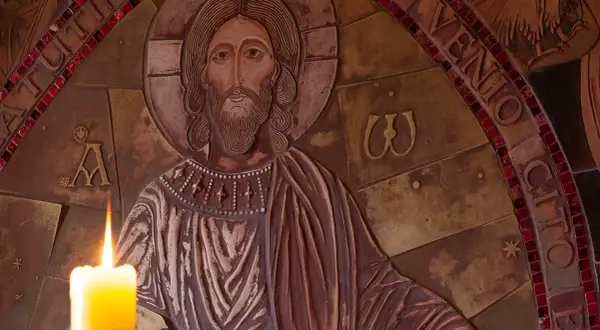 Płaskorzeźba Chrystusa z zapaloną świecą. Wokół napisy, w tym fragmenty nawiązujące do psalmów, np. psalm 99.