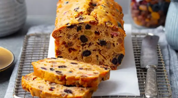 Pyszny keks Ani gotuje się w piekarniku, pełen bakalii. Pokrojone plastry kuszą aromatem.