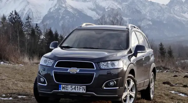 Chevrolet Captiva na tle górskich szczytów. Wiele osób szuka chevrolet captiva opinie, by sprawdzić, czy ten SUV sprawdzi się w trudnym terenie.
