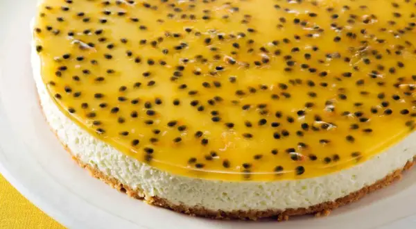 En krämig cheesecake med en krispig botten, toppad med en glansig gelé fylld med passionsfruktens svarta kärnor. En riktig passionsfrukt cheesecake-dröm!