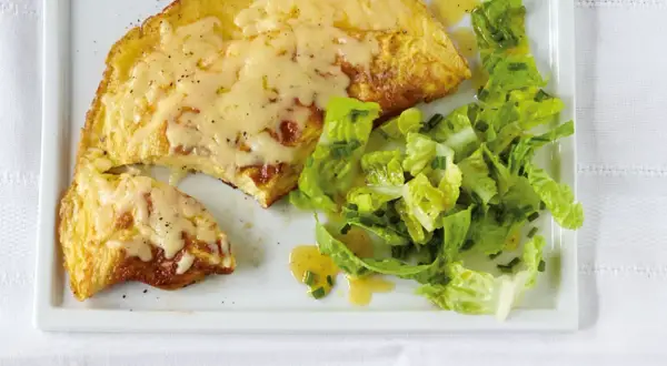 Ein herzhaftes Omelett mit geschmolzenem Käse, serviert mit einem frischen Salat. Perfekt für ein schnelles Omelette Rezept.