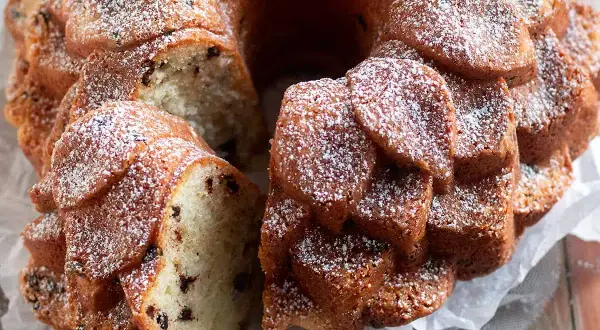 Una deliziosa torta al mascarpone con gocce di cioccolato, spolverata di zucchero a velo, pronta per essere gustata.