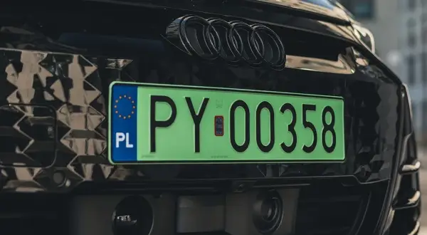 Zielona tablica rejestracyjna PY 00358 na czarnym Audi z czarnymi emblematami. To elw rejestracja, symbol nowoczesności.