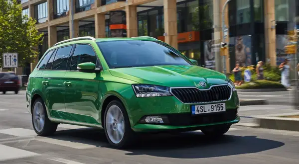 Grön Skoda Fabia kombi kör på stadsgata. Vissa modeller kan ha skoda fabia kamkedja problem.