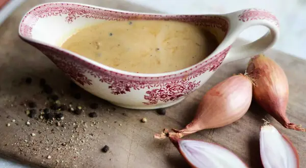Enkel pepparsås recept med schalottenlök och nymalen svartpeppar i en vacker såssip.