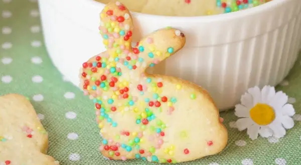 Bunte Osterkekse zum Ausstechen in Hasenform, verziert mit Zuckerstreuseln. Ein süßer Gruß für das Osterfest.