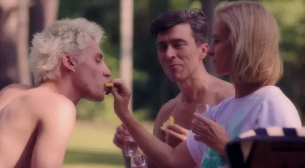 Trzy miłości film: blondyn z cytryną, mężczyzna wpatrzony w kobietę, która karmi blondyna.