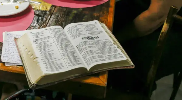 Co Biblia mówi o spowiedzi? Otwarta Biblia na stole, obok talerz i notatki.